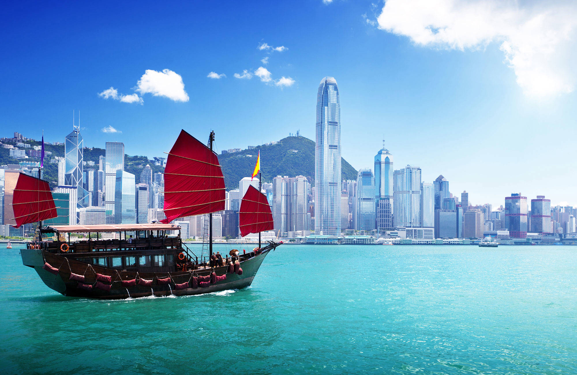 Boot in het water voor de kustlijn van Hong Kong | Beste reistijd mei | Beste bestemmingen mei | Reiskalender | KILROY