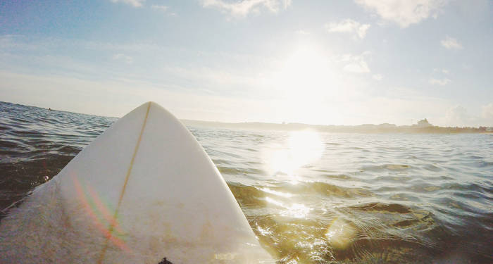 Stap op een surfplank in het water | KILROY