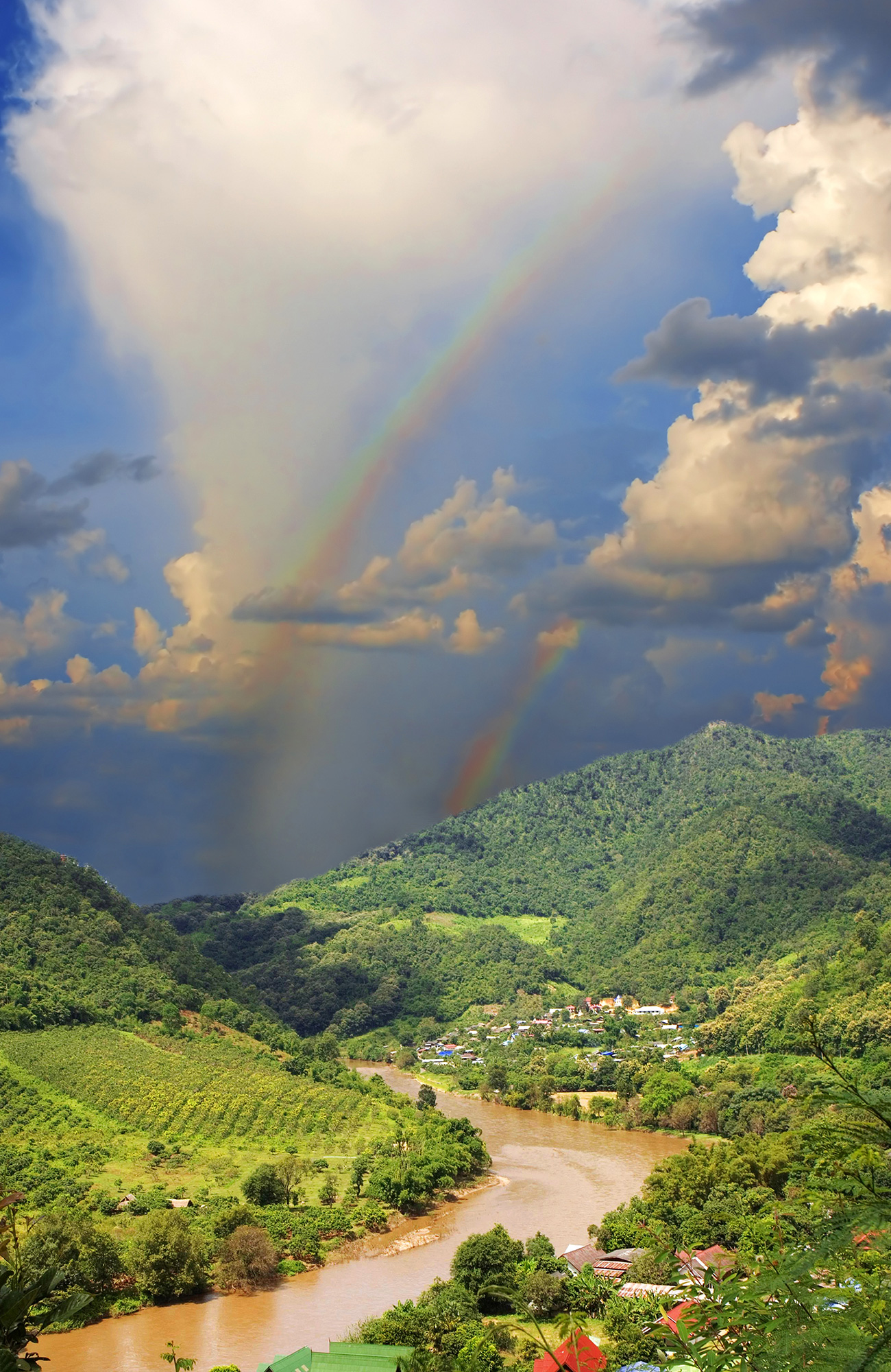 Twee regenbogen boven groen heuvelachtig landschap | Zeilen in Cambodja | KILROY