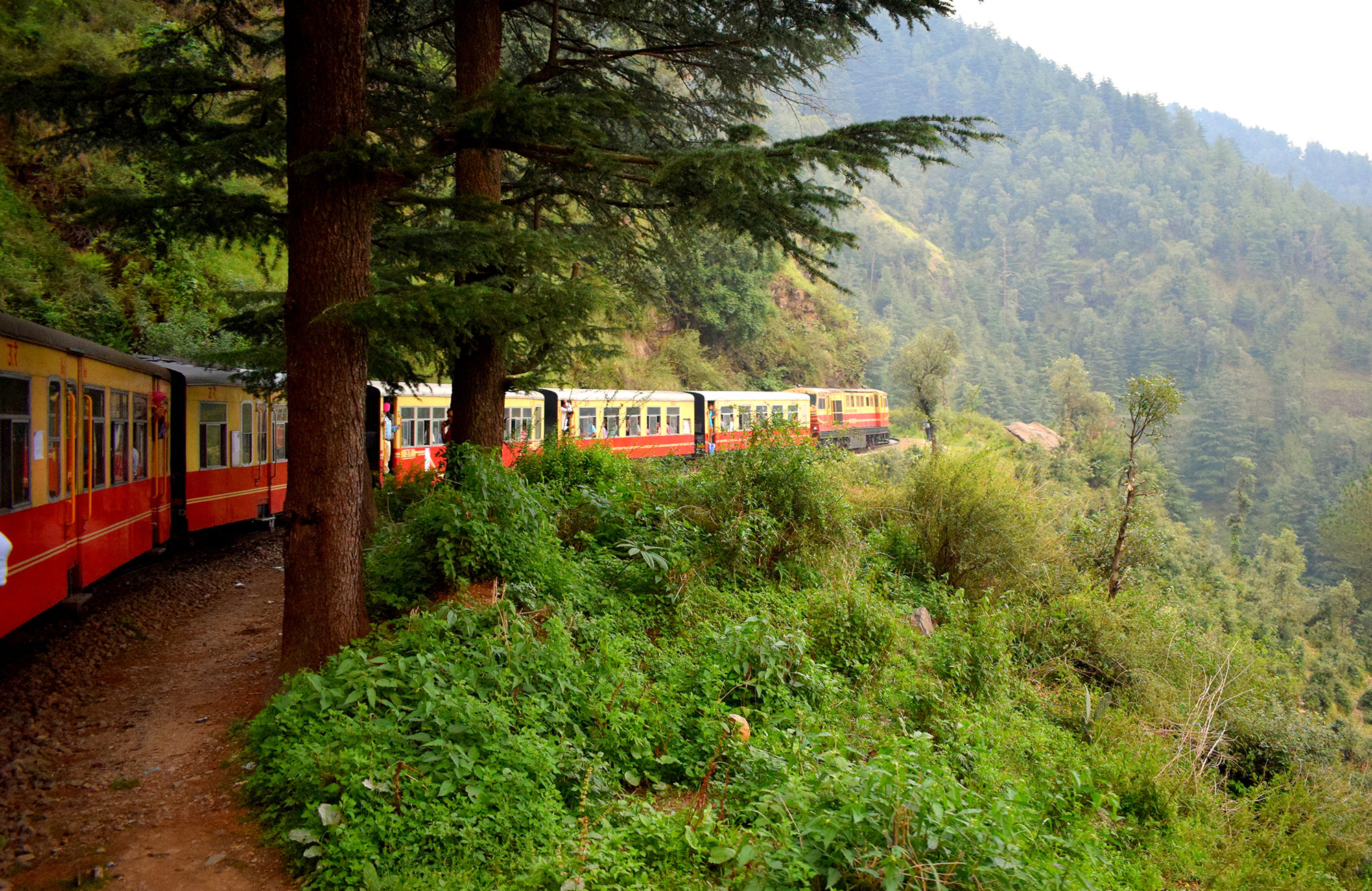 Trein rijdt door berglandschap | Met de trein door India | KILROY