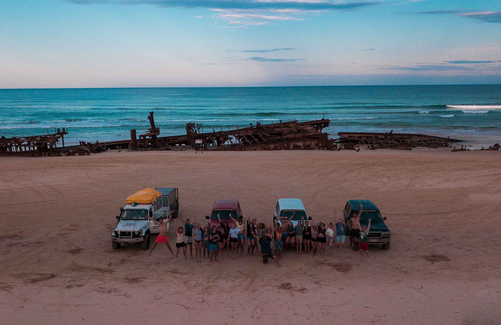 australia-fraser-island-group-of-people-with-shipwreck-on-beach