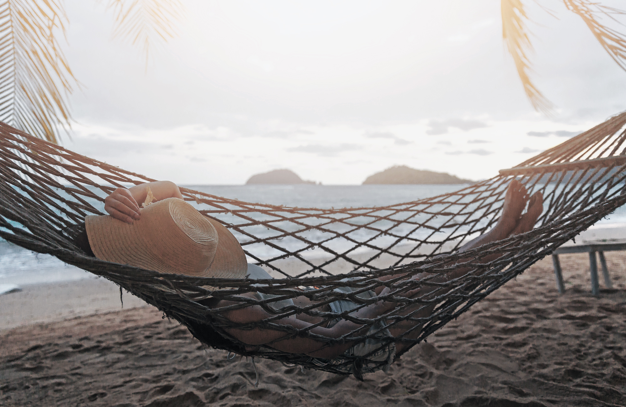 Girl in hammock on a tropical beach with the ocean in the background