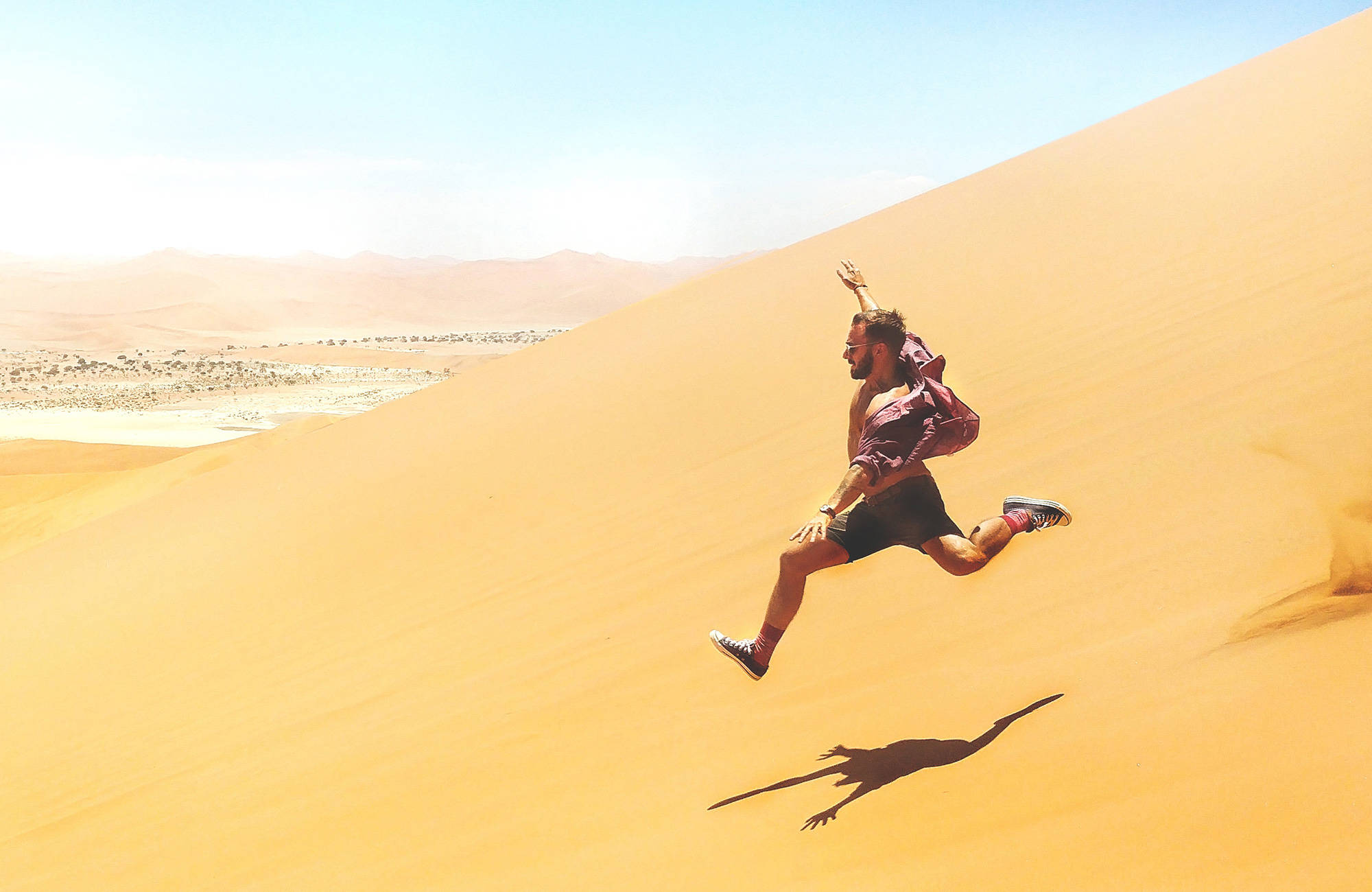 namibia-sand-dune-jump-male-backpacker
