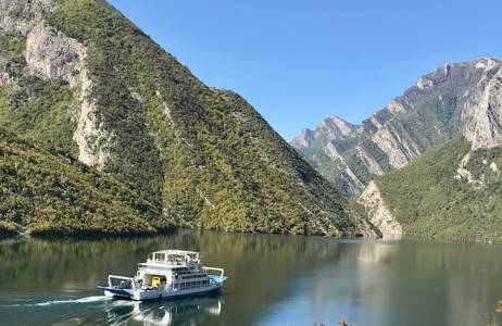 Veerboot op het water tussen de bergen | Reizen naar Albanië | KILROY