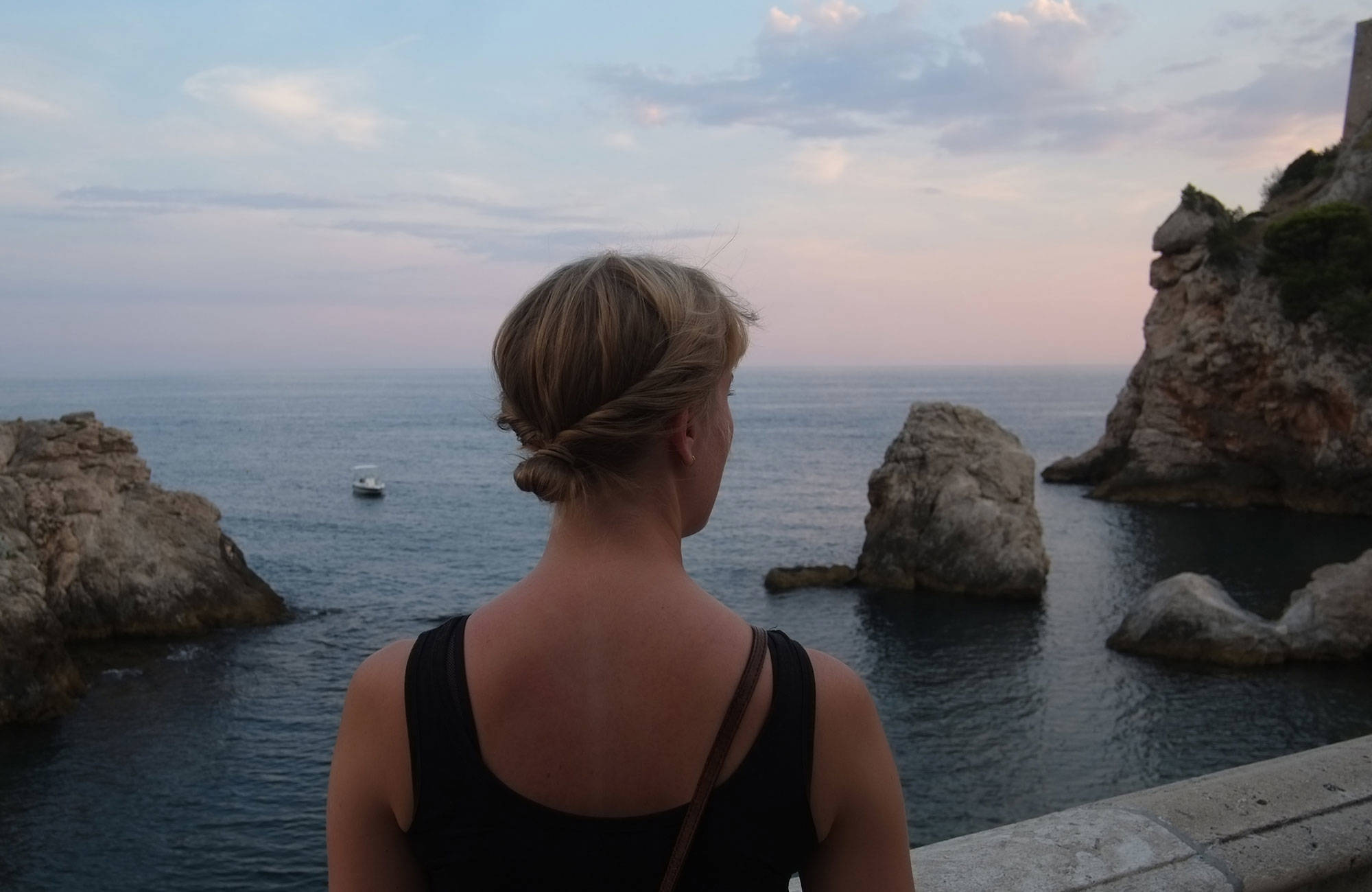 Reiziger kijkt uit op de oceaan in Dubrovnik | Reizen naar Kroatië | KILROY