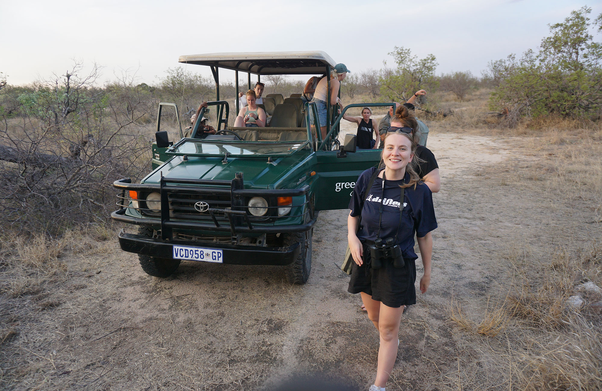 Image of a a group of travellers beside a safari jeep in South Africa - KILROY