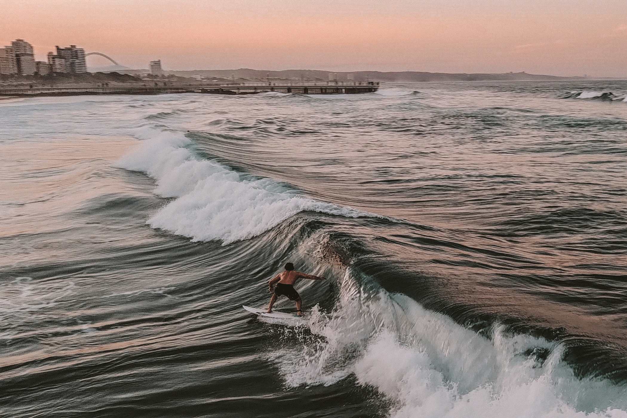 Lone Surfer On A Surfboard Just Off The Coast Of Durban In South Africa