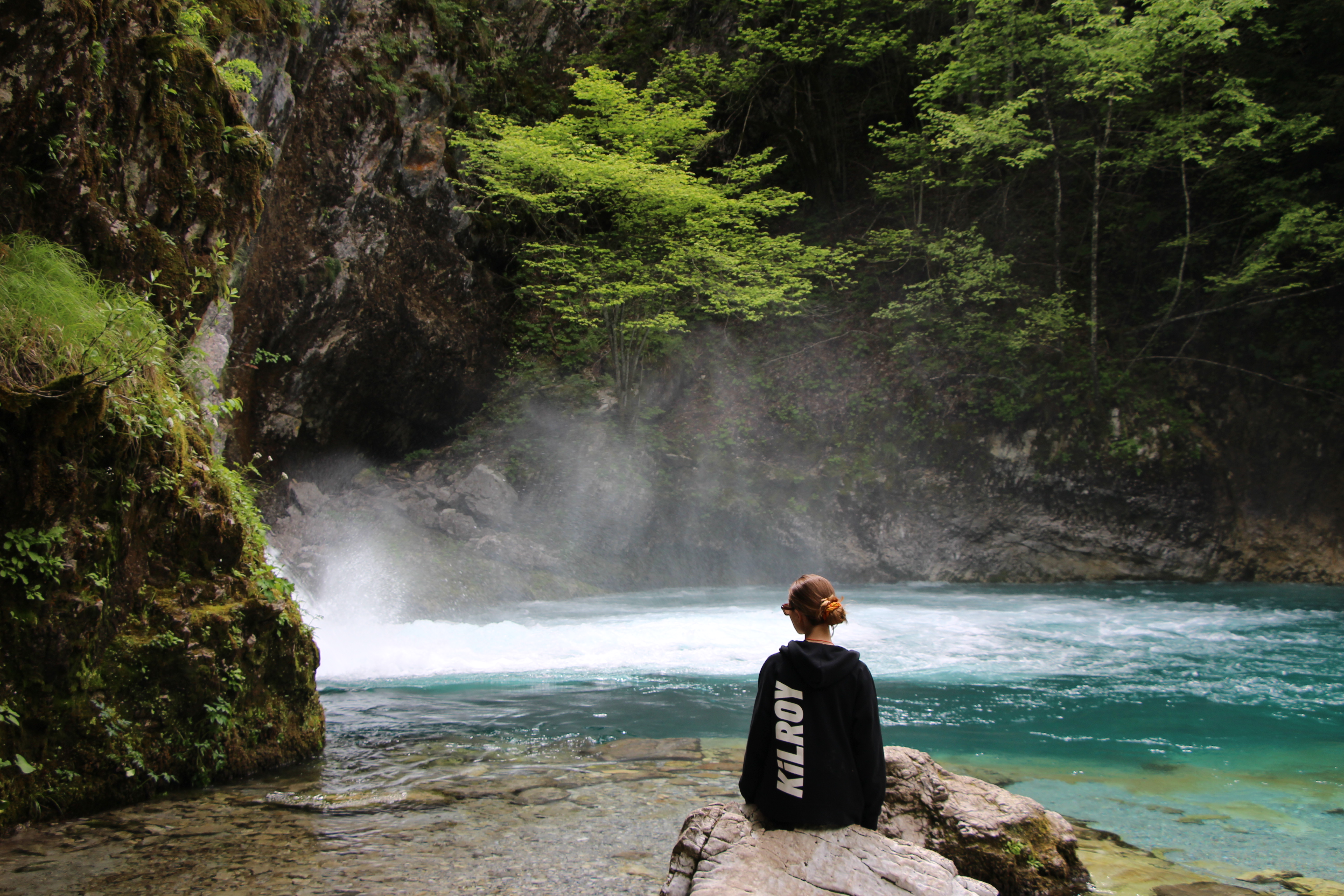 Girl with KILROY sweater looking at waterfall