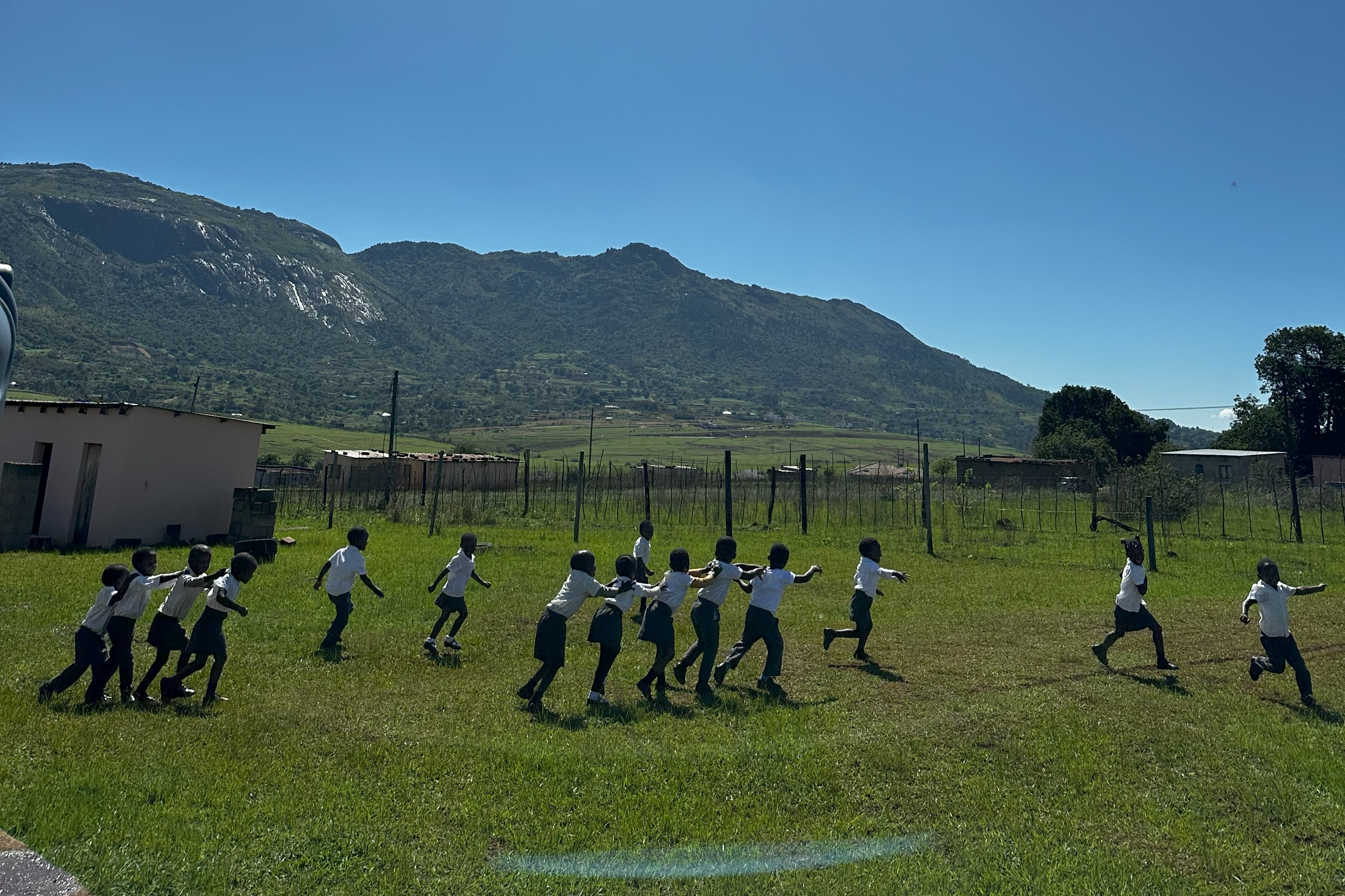 Man staat in een veld in Eswatini en kijkt naar het bergachtige uitzicht